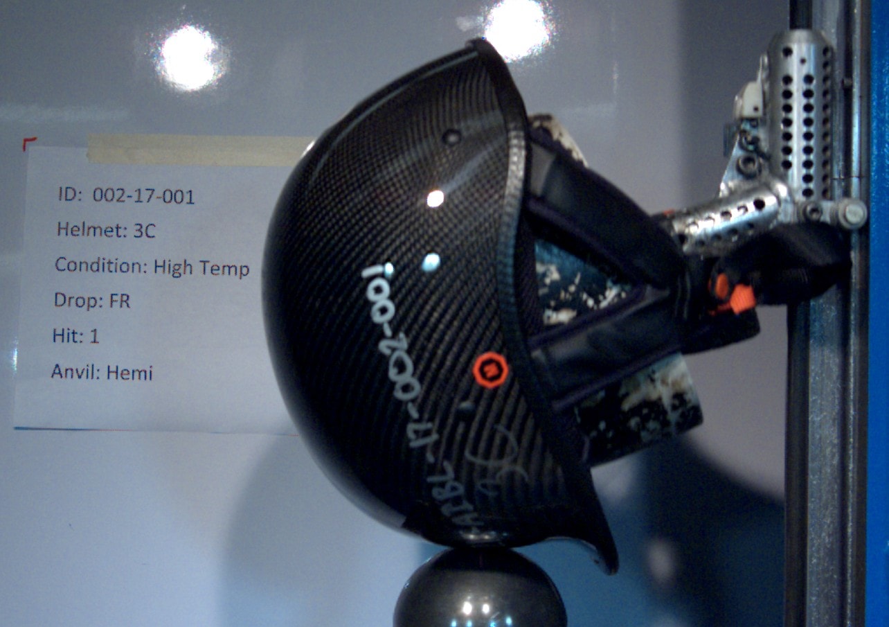 Helmet impact test with test data overlay showing ID, condition, and anvil type